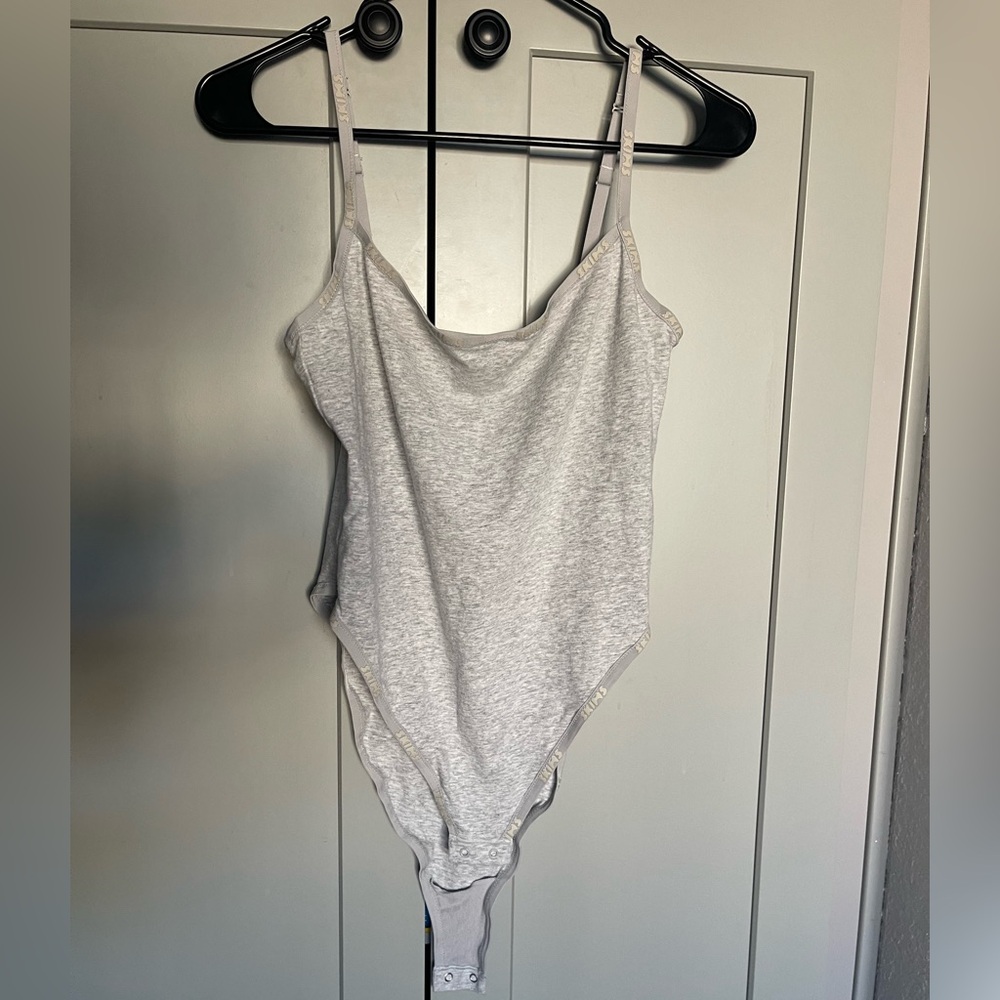 Skims body suit with skims logo around edges